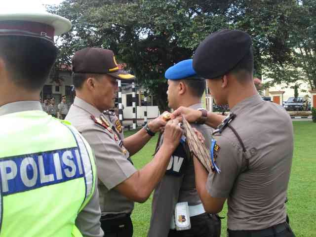 Kapolres Batanghari saat memasangkan tanda operasi simpatik kepada salah satu anggotanya 